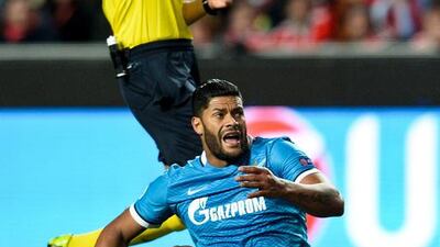 Referee Gianluca Rocchi (up) shows the yellow card to Benfica’s Brazilian defender Jardel Vieira (unseen) after foul on Zenit’s Brazilian forward Hulk (down) during the UEFA Champions League round of 16 football match SL Benfica vs FC Zenith Saint-Petersburg at the Luz stadium in Lisbon on February 16, 2016. / AFP / PATRICIA DE MELO MOREIRA