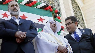 Interim prime minister for rebel-held areas, Ghassan Hitto (right), president of the Syrian National Coalition Moaz Al Khatib (left) and a Qatari official at the opening of the interim government's embassy in Qatar.