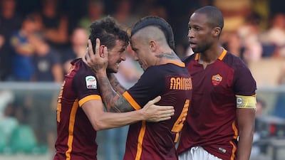 Roma's Alessandro Florenzi, left, celebrates with teammates Raja Nainggolan, center, and Seydou Keita after scoring, during a Serie A soccer match against Hellas Verona at the Bentegodi Stadium in Verona, Italy, Saturday, Aug. 22, 2015. Filippo Venezia / ANSA