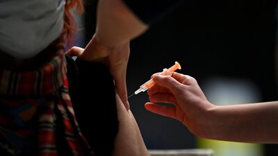 A patient receives an injection of the Oxford/AstraZeneca Covid-19 vaccine at the vaccination centre set up inside Brighton Centre in Brighton. AFP