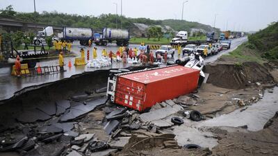 Emergency responders stand near an overturned lorry after a road was washed away by floodwaters in Boca Del Rio, on the outskirts of Veracruz. Tropical Depression 90-L has caused heavy rains in the states of southern Mexico, affecting homes, vehicles, roads, highways and bridges in many municipalities of the state of Veracruz, local media reported. Yahir Ceballos / Reuters