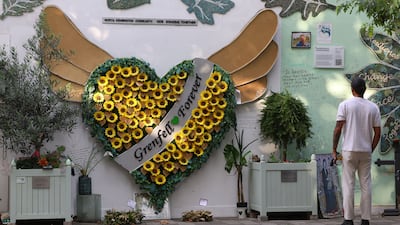 A person views dedications and messages on a wall of condolences near to the covered remains of Grenfell Tower, on the day of the publication of the second report of the UK public inquiry into the deadly 2017 Grenfell fire, in London, Britain, September 4, 2024. REUTERS / Toby Melville