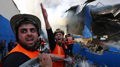Palestinian firefighters at a factory in the northern Gaza Strip that witnesses say was hit by Israeli artillery shells. Reuters