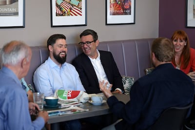 Britain's Prime Minister Andy Burnham, Labour MP for Erewash Adam Thompson and Britain's Housing Secretary Angela Rayner meet local business owners during a visit to Ilkeston, Derbyshire, on Tuesday. Reuters