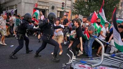 Police try to disperse protesters at the Vuelta a Espana on Sunday. AP