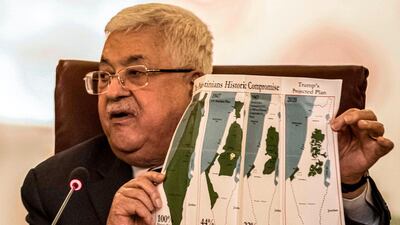 Palestinian president Mahmoud Abbas holds a placard showing maps of historical Palestine, left, the 1947 United Nations partition plan on Palestine, second left, the 1948-1967 borders between the Palestinian territories and Israel, and Palestinian territories under the proposed US peace plan, right, at an Arab League emergency meeting in Cairo on February 1, 2020. AFP