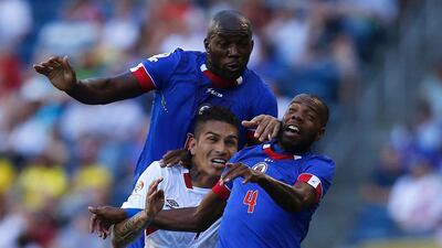 Peru’s Paolo Guerrero, centre, vies for the ball with Haiti’s Jean Marc Alexandre and Kim Jaggy. Jason Redmond / AFP