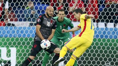 Albania defender Arlind Ajeti, left, blocks a shot from Romania's Bogdan Stancu. Sergey Dolzhenko / EPA