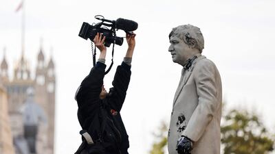 A cameraman homes in for a close-up of the oil-splattered statue. AFP