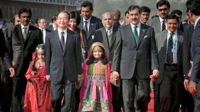 Wen Jiabao, the Chinese premier, left , and his Pakistani counterpart Yousuf Raza Gilani arrive for a tree-planting ceremony in Islamabad yesterday.