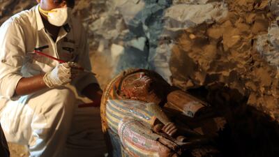 An Egyptian archaeologist works on sarcophagus at a recently discovered tomb in the Draa Abul Nagaa necropolis in Egypt. Khaled Elfiqi / EPA