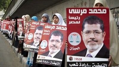 Egyptian women line up to form a human chain on Thursday as they hold posters of Muslim Brotherhood presidential candidate.