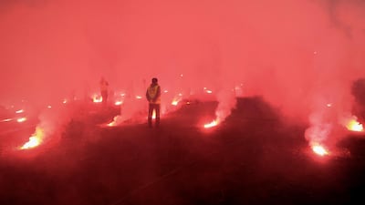 Stewards stand among burning flares during the Serbian Cup semi-final. AFP