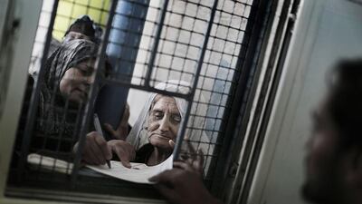 Palestinian refugee women wait to receive food aid at the United Nations Relief and Works Agency center in Al Shatea refugee camp, west of Gaza City. Ali Ali / EPA
