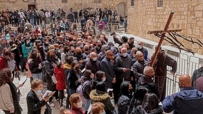 Christian worshippers reach the Church of the Holy Sepulchre in Jerusalem's Old City during the Good Friday procession on April 2, 2021. AFP