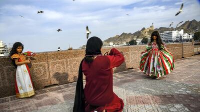 An Omani girl poses for a picture while dressed in traditional costume by the waterfront in Muscat. AFP