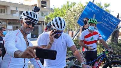 Lebanese sportsman Maxime Chaya takes a picture with US former professional cyclist Lance Armstrong prior to "Bike for Beirut" charity tour at the site of the August 4 port explosion. AFP