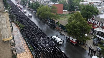 Police personnel salute as officers carry the casket of NYPD officer Didarul Islam killed in the Manhattan shooting in New York City. AFP