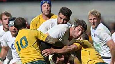 England's Simon Shaw, centre, is wrapped up by Quade Cooper (10) and Luke Burgess.