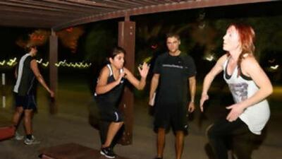 from left, Naha Jamarni, coach Derrick Branford and Leah Oatway push through the 30 Minutes to Fitness class at Safa Park in Dubai.