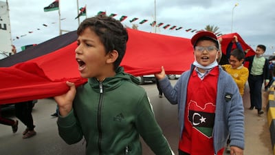 Children carry a giant Libyan flag as part of the celebrations in Tripoli. AFP