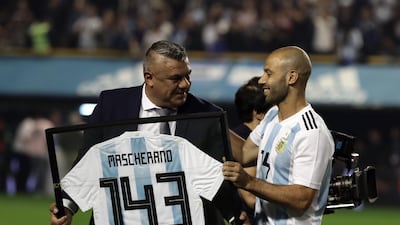 Argentina's Javier Mascherano receives from the president of the Argentine Football Association, Claudio Tapia, a jersey marking his 143th match with the national team. Alejandro Pagni / AFP