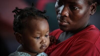 Celimaine Heixil, 29, holds her daughter, both displaced by gang war violence, at Darius Denis school. Nearly half of the country’s population is struggling to feed themselves due to the conflict, unable to work, the families depend on food rations and hygiene kits brought in by non-governmental organisations
