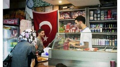 Shoppers at the Abu Al Ez Ardogan Sandwiches Restaurant and Grocery in East Jerusalem. The shop pays homage to the Turkish prime minister. Adam Reynolds for The National