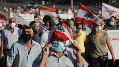 People wave Lebanese flags and chant to mark the first anniversary of anti-government protests. Getty Images