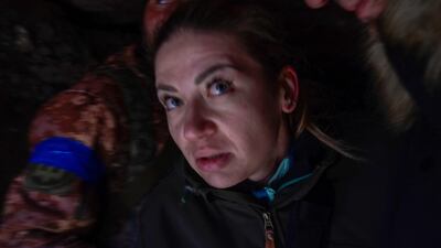 A woman takes cover in a military trench as a Russian jet fighter flies overhead, near the military school hit by Russian rockets the day before, in Mykolaiv. AFP
