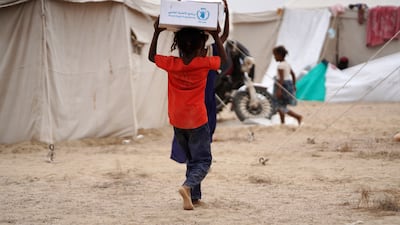 Displaced people receive aid provided by UN relief groups at a makeshift camp in Aden, Yemen on September 17. EPA