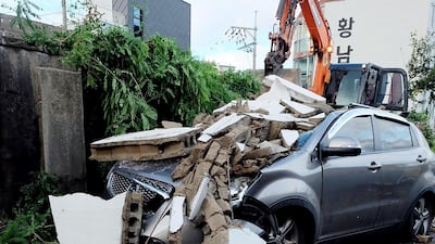 A damaged car is seen under a wall in Ulsan. AFP