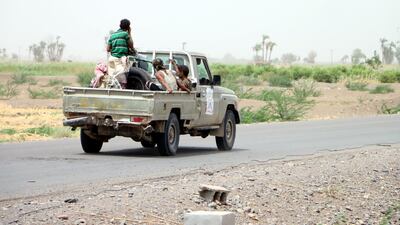 A soldier rides on a pick-up truck during military operations.
