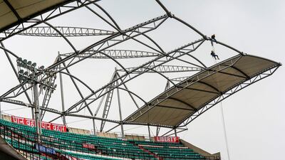 Workers tie a wire to the top of stands at the Rajiv Gandhi International Cricket Stadium in Hyderabad. AFP