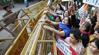 Members of All India Mahila Congress, women’s wing of Congress party, shout slogans and carry placards next to a police barricade during a protest against the rape of a female passenger, in New Delhi December 8, 2014. Anindito Mukherjee / Reuters