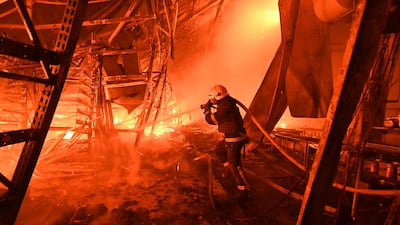 A Ukrainian firefighter extinguishes a blaze at a hypermarket hit by a Russian air strike, in Kharkiv. AFP