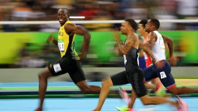 Usain Bolt smiles for the camera as he crosses the finish line to win the men's 100m final at the 2016 Rio Olympics on Sunday. Kai Pfaffenbach / Reuters / August 14, 2016