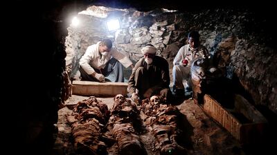 Archaeologists work on mummies found in the New Kingdom tomb belonging to a royal goldsmith in Luxor, Egypt. Nariman El-Mofty / AP Photo