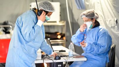 Paramedics work in a tent that was set up outside the hospital of Cremona, northern Italy. AP