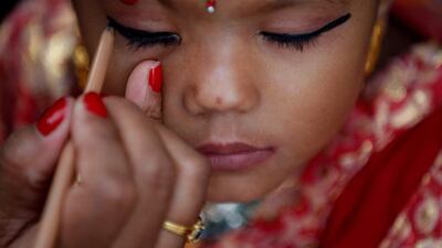 A woman applies makeup to a young girl dressed as the Living Goddess Kumari during the Kumari Puja festival in Kathmandu, Nepal. The festival is a gathering in which young girls pose as the Living Goddess Kumari and are worshipped by people in belief that their children will remain healthy. Navesh Chitrakar / Reuters
