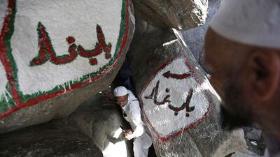 A Muslim pilgrim crouches as he exits and makes his way down Mount Al-Noor, where Muslims believe Prophet Mohammad received the first words of the Quran through Gabriel, in the holy city of Mecca. Muhammad Hamed / Reuters