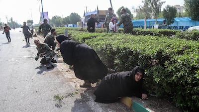 Iranian soldiers, women, and children lay down and run during the attack. EPA