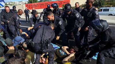 Members of the Israeli security forces remove demonstrators blocking a highway to Jerusalem. Reuters
