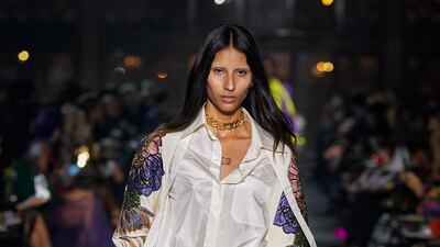 An embroidered cape is worn with an untucked silk shirt at the Valentino spring/summer 2022 show