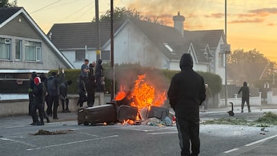 Bins on fire. Twelve officers were injured and 16 arrests were made. Reuters