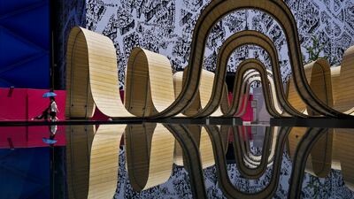A family walks past an art installation at an outdoor shopping mall in Beijing. AP