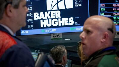 Traders work by the post that trades Baker Hughes on the floor of the New York Stock Exchange. The oil services company's quarterly loss was worse than analysts expected. Brendan McDermid / Reuters