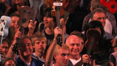 Members of the public wave their instruments in the air after performing with the Ukulele Orchestra of Great Britain at the BBC Proms of London's Royal Albert Hall.