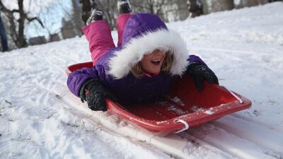 A young girl sleds down a hill in Central Park after winter storm Hercules in New York, United States. John Moore/Getty Images/AFP