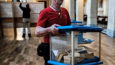 Municipal employees prepare a polling station in Lyon on the eve of the French presidential election's first round. Jeff Pachoud / AFP